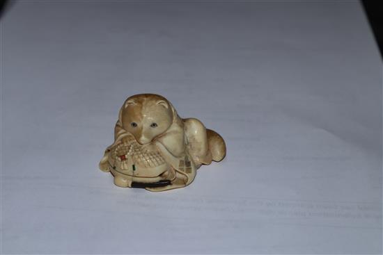 A Japanese Meiji period carved ivory netsuke of a fox cub on a cushion, with inset eyes 3.5cm high